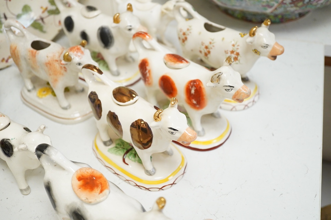 A large collection of English pottery cow creamers, Staffordshire figures and cruets a blue and white teapot and sponge ware dish-34cm diameter, (26)